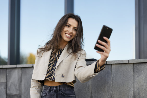 迷人的年轻女孩用手机自拍。一个美丽的网红与她的粉丝交流，录制视频。图片下载