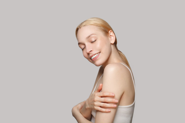 快乐的金发女子与马尾微笑和笑孤立在灰色的背景图片下载