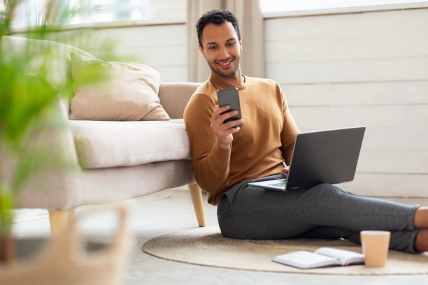在家使用智能手机和电脑的男人肖像图片下载