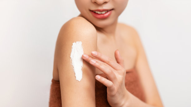 亚洲女性在肩膀上涂抹身体霜的特写图片下载