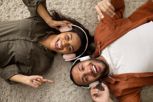 戴着耳机听音乐的黑人夫妇，室内，顶视图图片下载