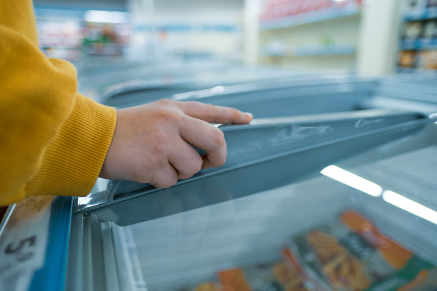 年轻女人在超市握住冰箱的右手特写图片下载