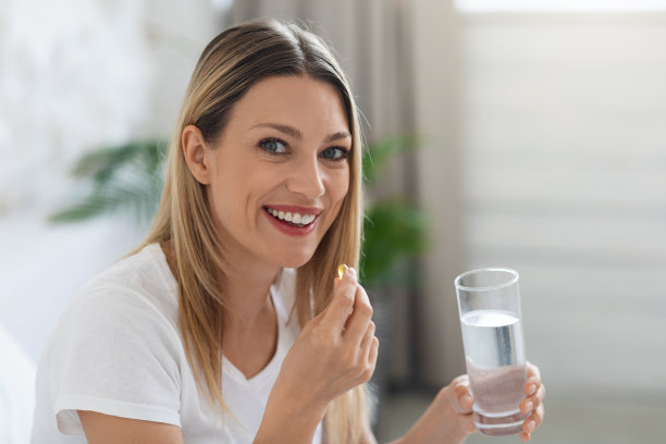 微笑的漂亮女人服用药丸后醒来图片下载