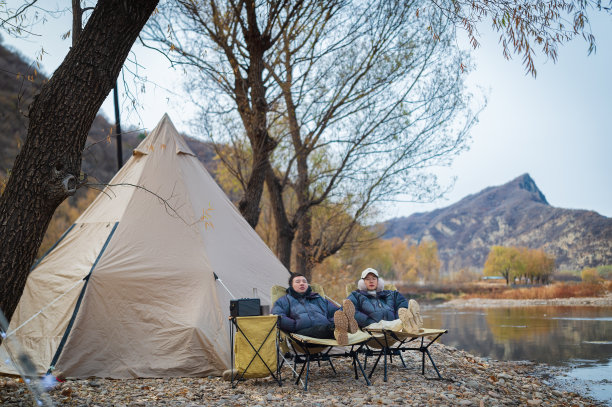 一对夫妇在河边露营度过了他们闲暇的秋季时光图片下载