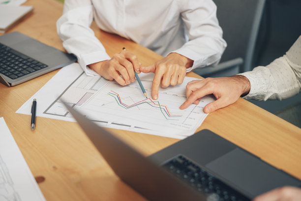 近距离的业务团队正在分析新的财务项目，同时在办公桌上一起工作图片下载