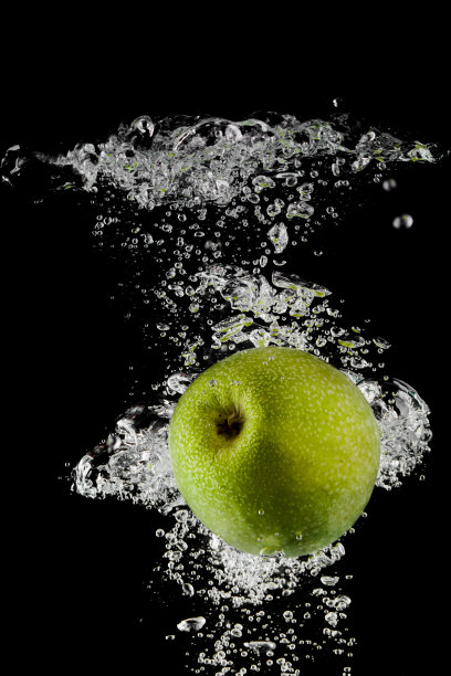 苹果在黑色背景下落入水中图片下载