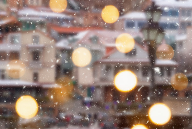 第比利斯市美丽的冬季模糊背景与飘落的雪和散景灯图片下载