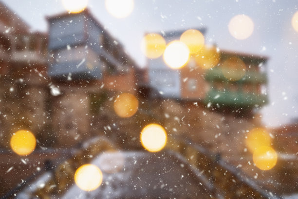 第比利斯市美丽的冬季模糊背景与飘落的雪和散景灯图片下载