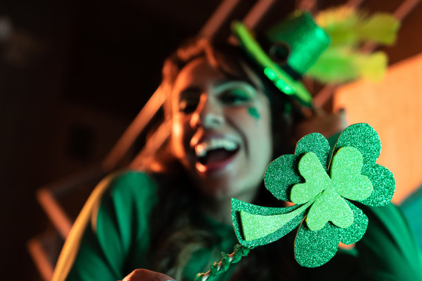 圣帕特里克节的派对，背景中有一个女人手持三叶草图片下载