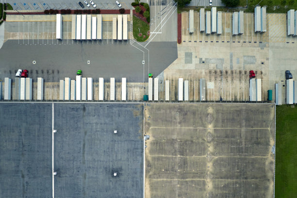 大型商业分销仓库，许多半卡车卸载和上传零售产品进行国际运输。全球市场经济概念图片下载