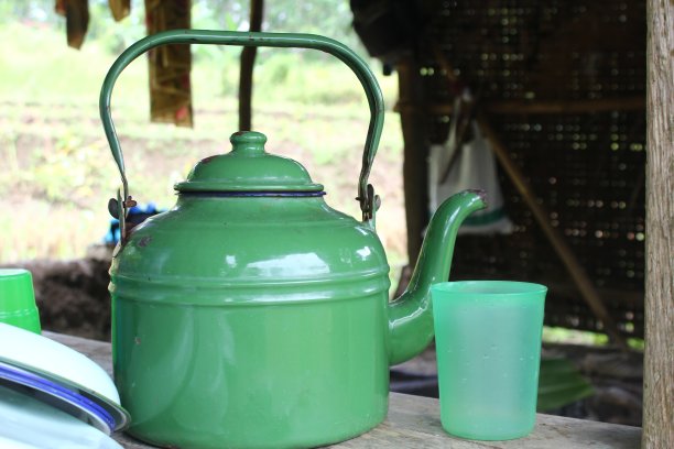 古老的水壶放在古老的木头上。这个旧茶壶是绿色的图片下载