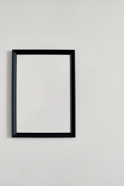 白色墙上挂着一个黑色边框的空相框图片下载