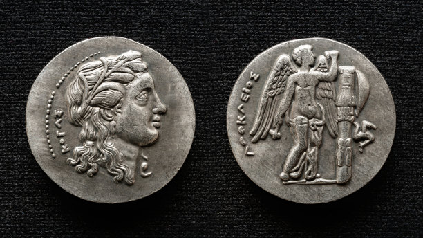 古希腊钱币，宏观的钱币上有人物肖像和长翅膀的神图片下载