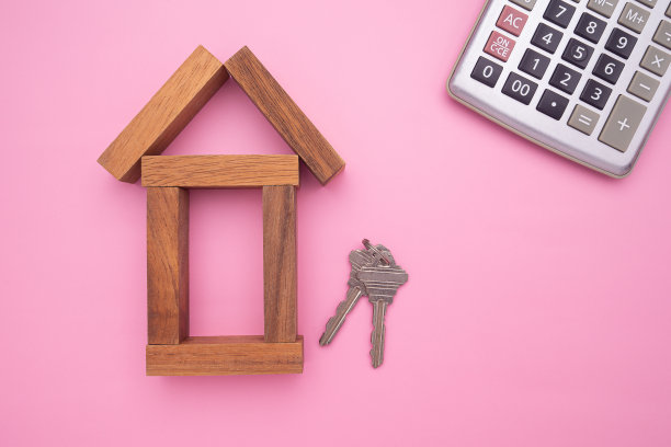 小木屋，房子钥匙和计算器在粉红色背景的住房贷款。图片下载