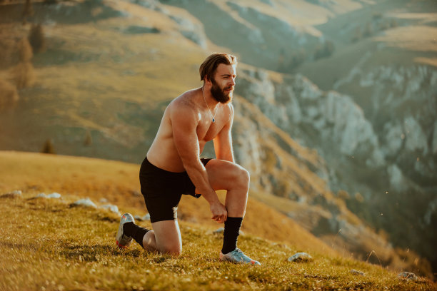 日出时分，一名意志坚定的运动员在山顶准备开始训练。图片下载