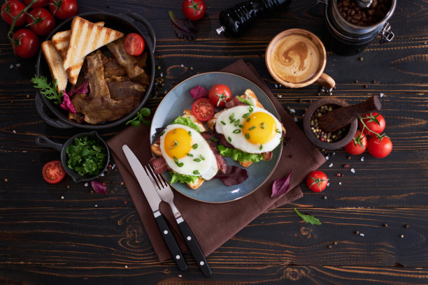 美味的早餐-煎蛋吐司，熏肉，西红柿放在木制的餐桌上图片下载
