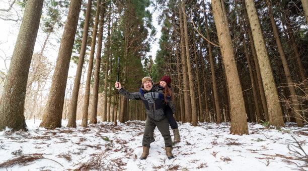 有趣的情侣在森林里骑着小猪骑着运动相机拍视频图片下载