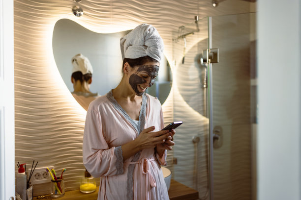 女子在浴室使用移动应用程序图片下载