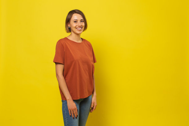 金发女人在工作室的黄色背景图片下载