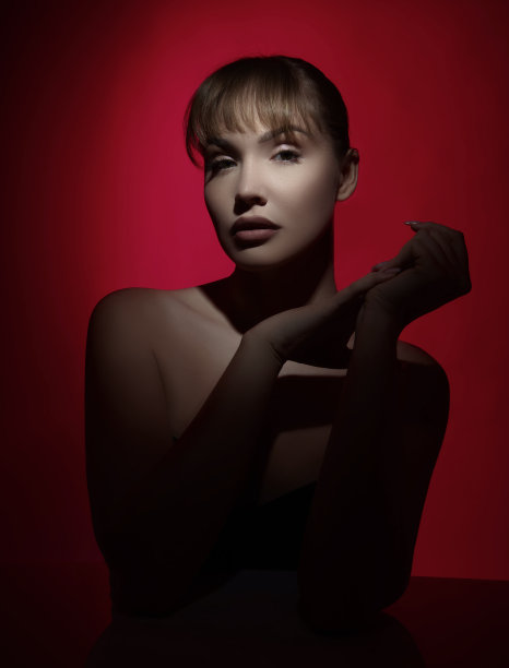 美丽女人的肖像在戏剧性的形状照明下拍摄的工作室。图片下载