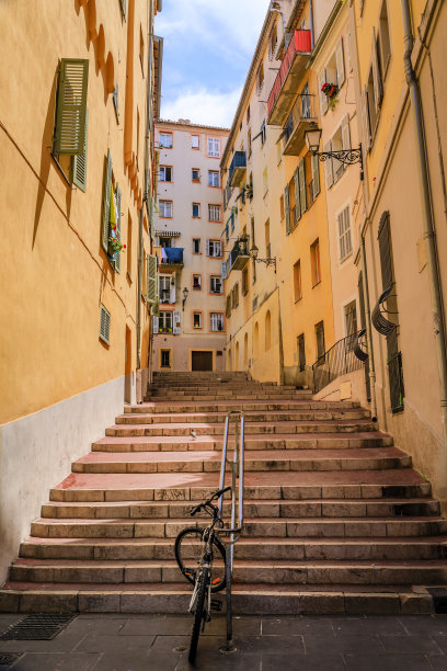 在法国尼斯老城区，有楼梯的弯曲街道上的传统房屋图片下载