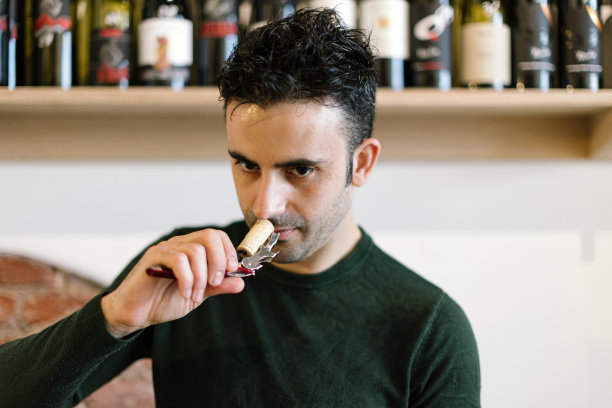 酒吧侍酒师嗅了嗅刚刚打开的软木塞图片下载