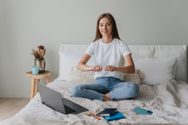 有目的的金发白人学生女孩坐在床上笔记本电脑准备考试回家。美丽的美国年轻女子在卧室工作。自信的意大利女企业家。国内休闲。图片下载