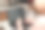 成熟的女人在家里使用笔记本电脑。坐在厨房的一张桌子旁，手里拿着杯子。图片下载