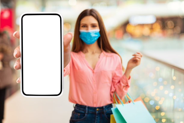 一名女子戴着口罩在商场展示大智能手机屏幕图片下载