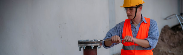 安装消防喷水灭火系统。在工业厂房，管道组装，红色消防管道，消防承包商使用剪刀升降机高工作图片下载