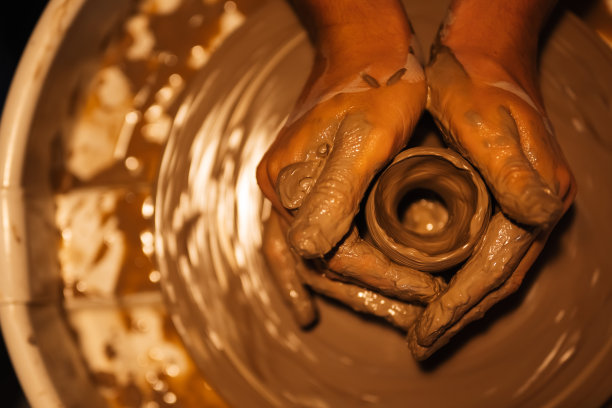 近距离的熟练的手雕刻陶罐上的陶轮图片下载