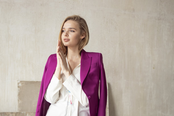 一个年轻女孩的肖像长金发在紫色的西装图片下载