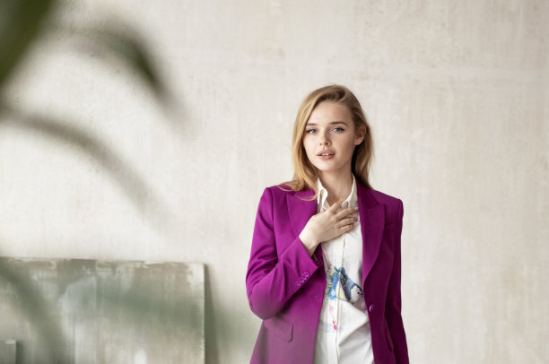 一个年轻女孩的肖像长金发在紫色的西装图片下载
