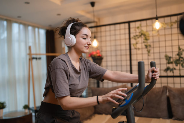 一名年轻女子在室内自行车固定健身车上训练图片下载