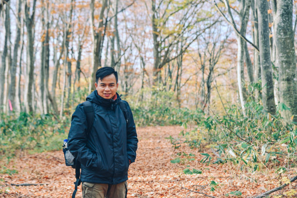 亚洲男子旅行者享受秋天的森林图片下载