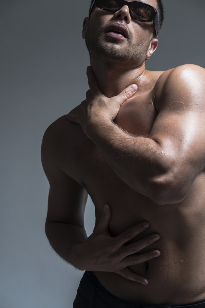一名肌肉发达的拉丁裔男子在一家照相馆里用身体表情摆姿势拍照图片下载