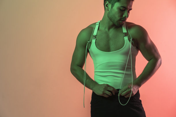 一名肌肉发达的拉丁裔男子在一家照相馆里用身体表情摆姿势拍照图片下载