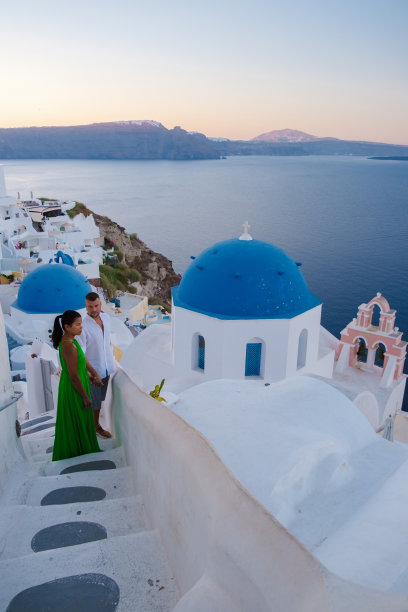 情侣参观希腊圣托里尼岛，男人和女人参观粉刷成白色的希腊村庄伊亚图片下载