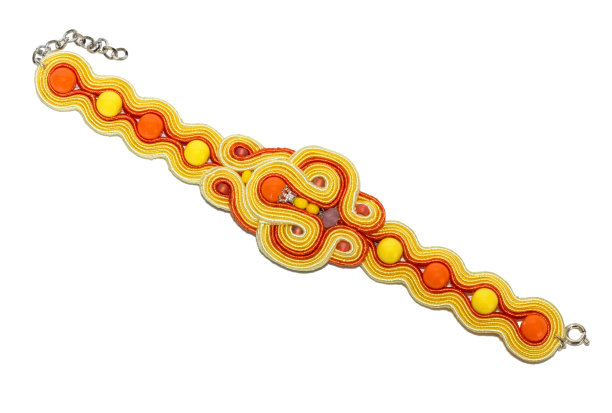 美丽，现代和积极的手镯编织线和珠子的黄色和橙色。谎言在白色的背景上图片下载