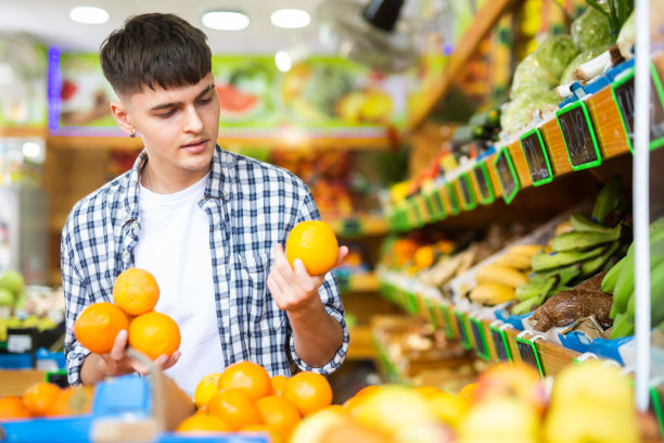 专注的买家在柜台上挑选橙子图片下载