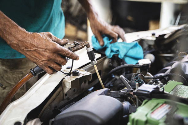 从车库的发动机中吸出的机械油。图片下载