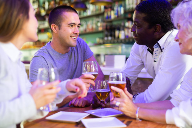 快乐的朋友在餐厅喝着啤酒聊天图片下载