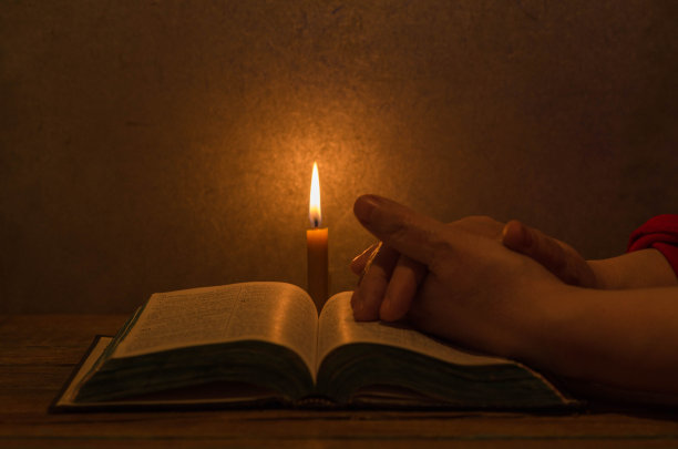 人们坐在舒适的环境中，点着蜡烛阅读圣经图片下载