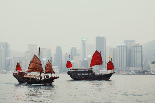 香港维多利亚港背景下的红色帆传统帆船图片下载