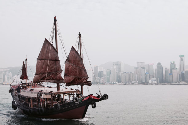 香港维多利亚港背景下的红色帆传统帆船图片下载