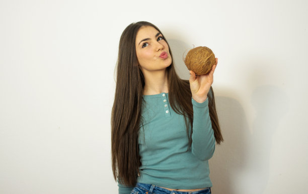 年轻漂亮的女人拿着椰子图片下载