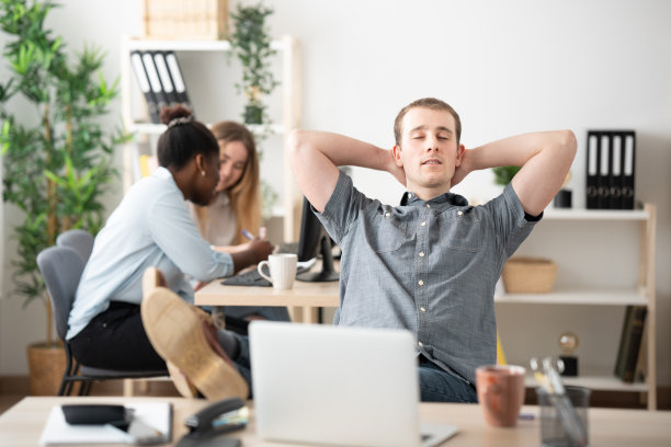 办公室职员在办公室里把手放在脑后放松图片下载