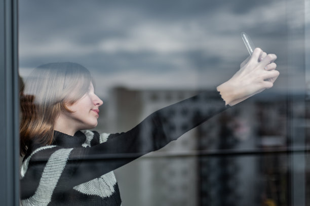 城市里有影响力的少女，靠窗，用智能手机图片下载