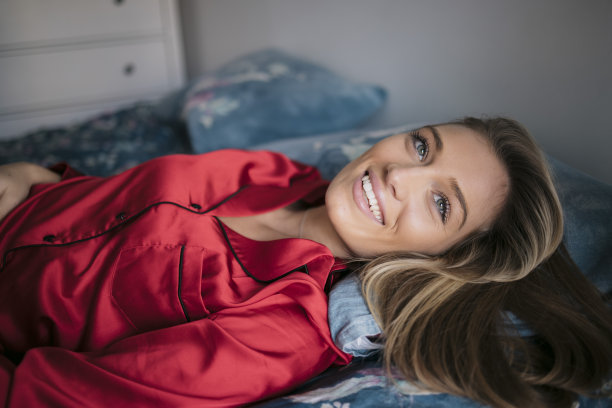 迷人的白人女性在红色睡衣躺在床上图片下载