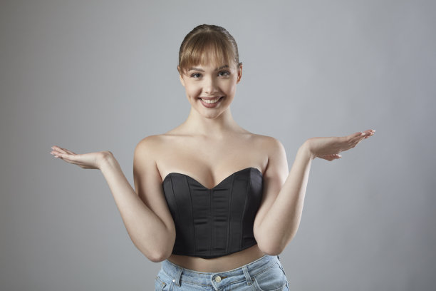 美丽的金发女人与刘海微笑，双臂伸展，在她的手掌里拿着什么。图片下载